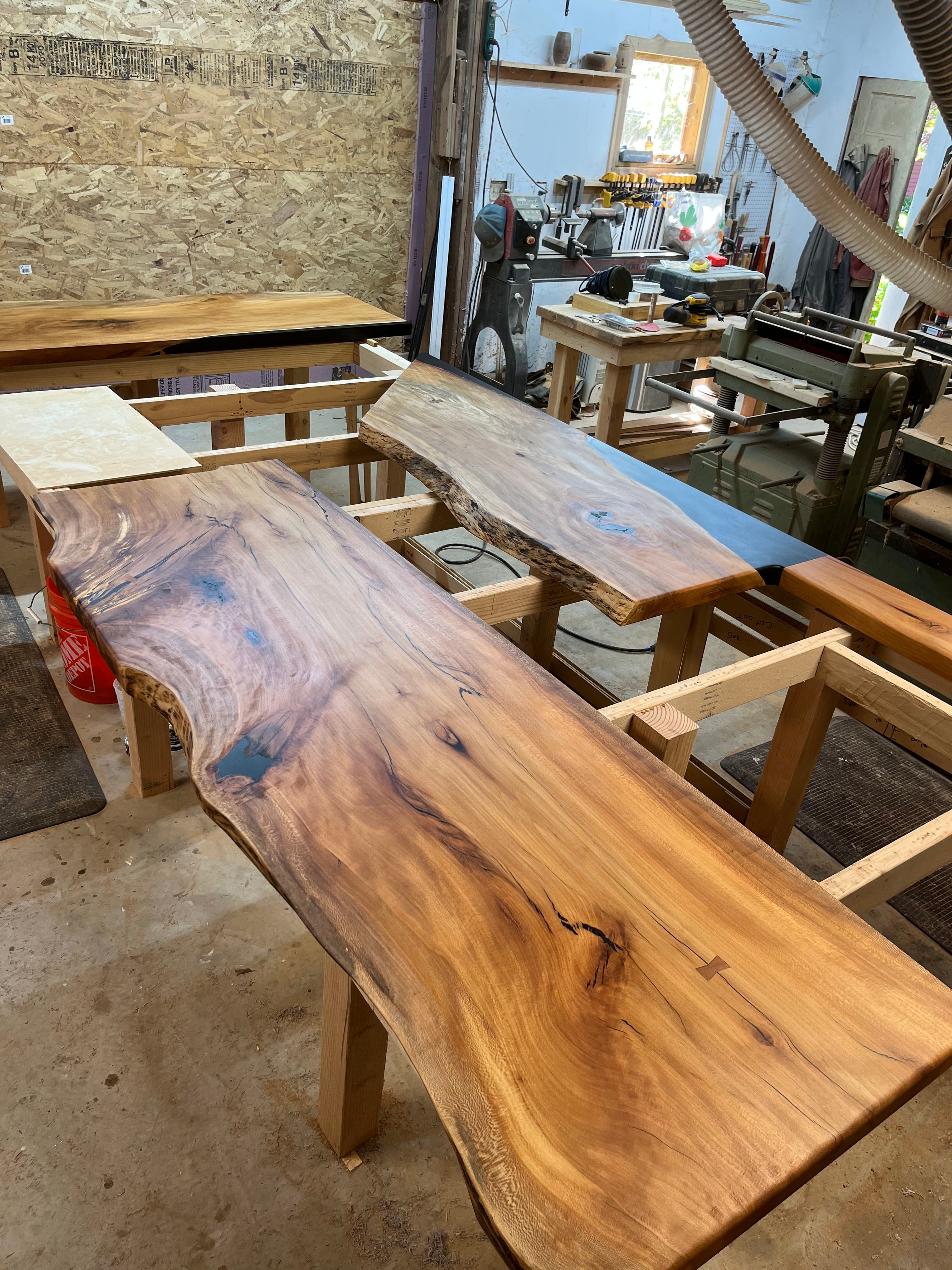 Live edge hardwood slab on sawhorses in the Tougas Timberworks shop