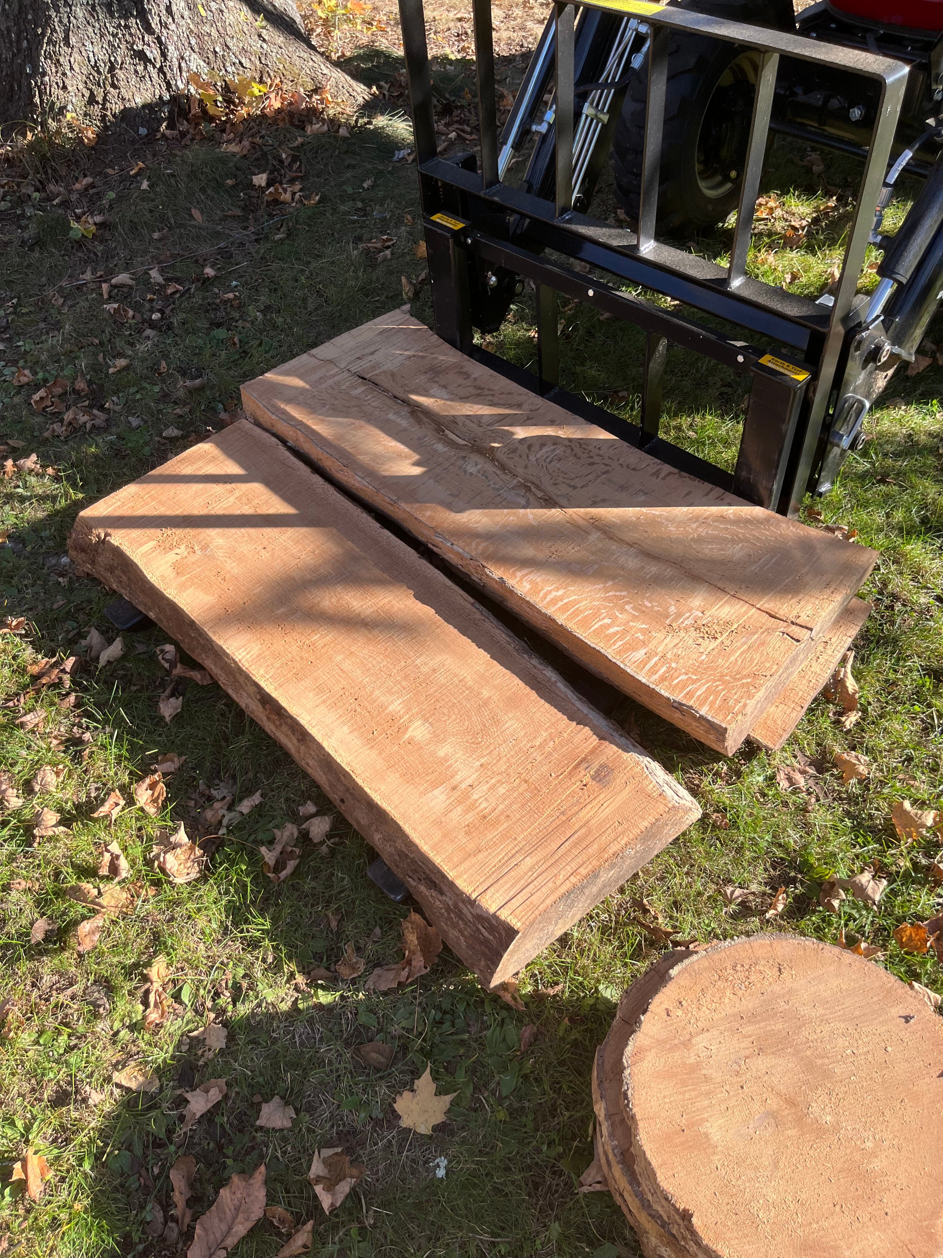 Freshly milled slabs with a log end outdoors, showing the milling setup and scale
