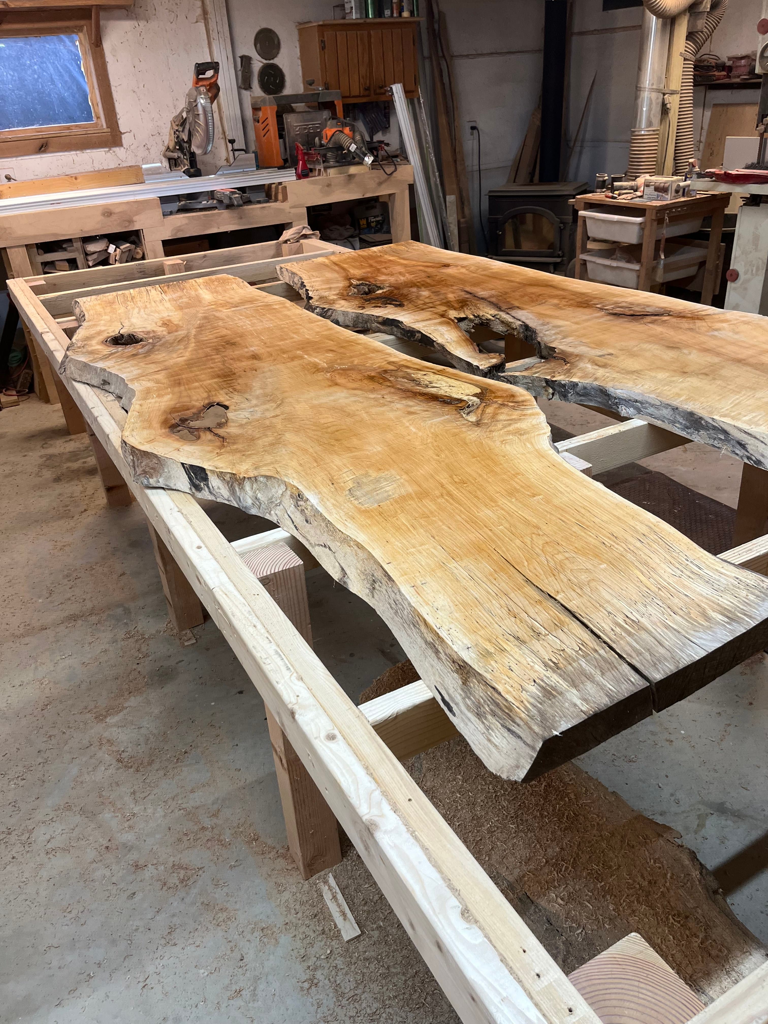Live edge slab on sawhorses inside the Tougas Timberworks shop in Monroe, CT