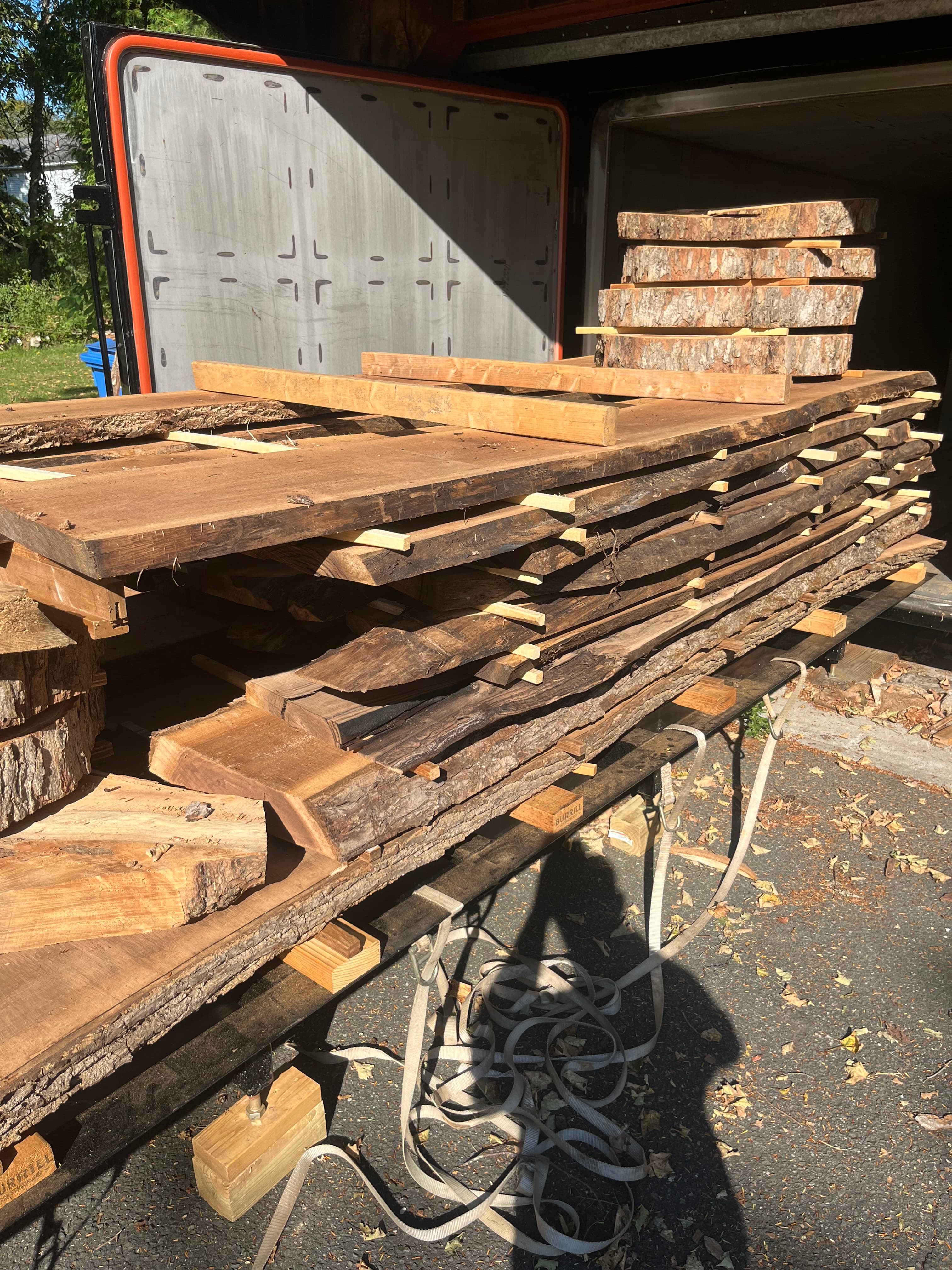 Walnut lumber stacked and strapped on a truck bed, ready for delivery